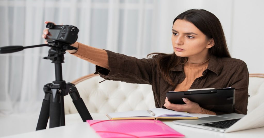 A woman using a camera, highlighting her career path as an aspiring creator in video production.