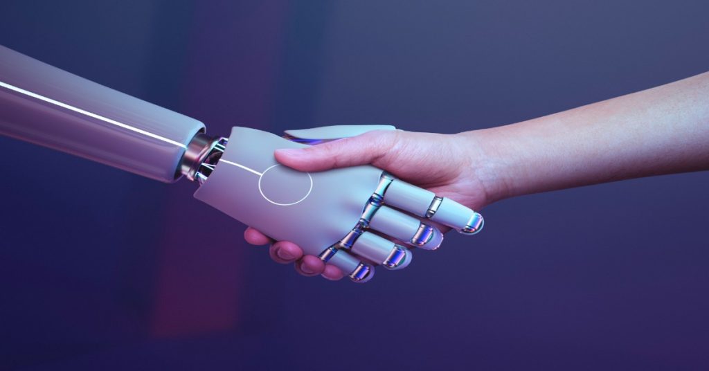 A robot hand and a human hand shaking hands, to represent a new era of collaboration in video production.
